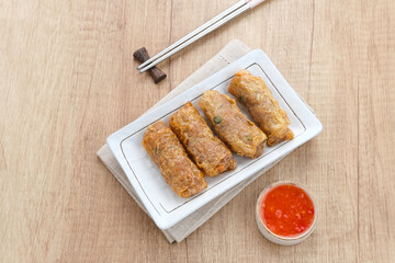 Lumpia Kulit Tahu, chicken shrimp spring rolls wrapped in tofu skin. Served with sauce.
