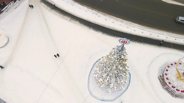 Christmas tree in the city square with bright lights and golden garlands. New Year's, green spruce fabulously decorated and covered with snow. City of Vladimir, Cathedral Square, Russia. UHD 4K.