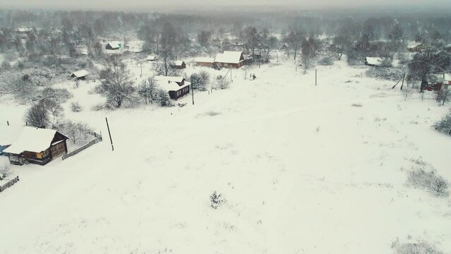 Aerial view of a winter snowy village with a wide square in the middle. Central Russia. Fabulous winter natural landscape, background, screensaver, footage, video. UHD 4K.