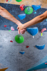 Fototapeta na wymiar Bouldering Concepts. Closeup of Hands Of One couple Preparing To Bouldering climbing up the wall together.