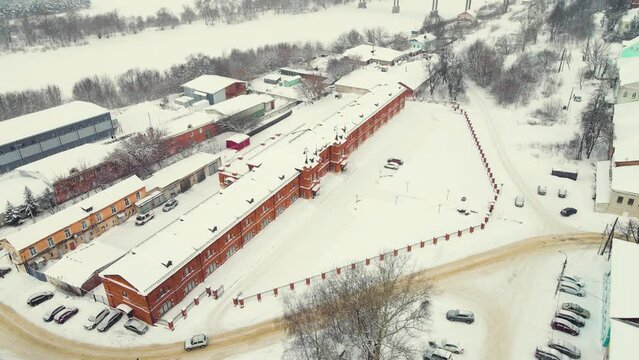 Aerial view of winter cityscape with houses and road. Everything is covered with snow. Video intro, footage in cloudy weather for intro, background, titles. UHD 4K.