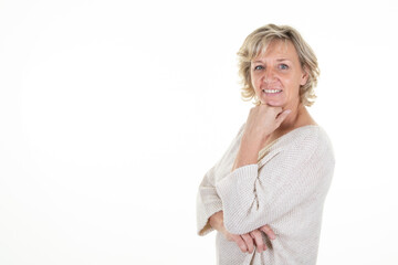 60 senior blond woman with blonde hair blue eyes on white background and hand on chin copy space