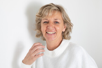 60s senior woman mature with blue eyes blond in wool sweater on white background