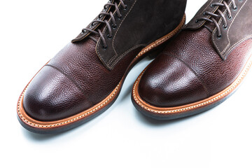 Footwear Ideas. Closeup of Toes of Premium Dark Brown Grain Brogue Derby Boots Made of Calf Leather with Rubber Sole Placed in Line Together Over White