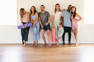 Fototapeta na wymiar Group of diverse people smiling while standing in a yoga studio