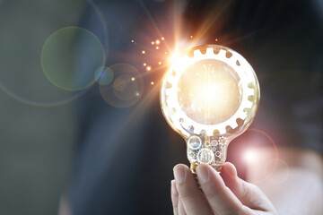 The concept of innovation idea and knowledge. Hand holding light bulb with a gear icon of ​​inspiration thinking. Innovation and development. New business idea concept