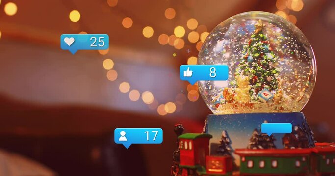 Animation of social media icons over christmas tree in snow globe
