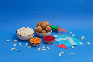 Happy Makar Sankranti, Pongal and Uttarayan with Kite, haldi kum kum bowls and tilgul sweets