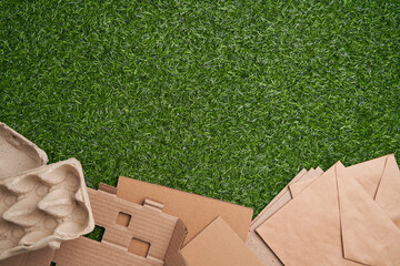 Paper collected for recycling on green grass background.