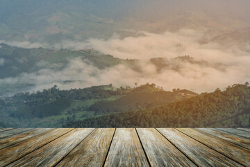 Wood floor foreground on sunrise landscape with mountain and fog mist winter weather sun lighting...