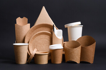 A set of eco-friendly food delivery containers made of paper and cardboard on a black background. Zero waste concept