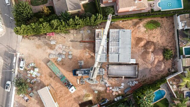Top down aerial timelapse of construction crane workers assembling modular home