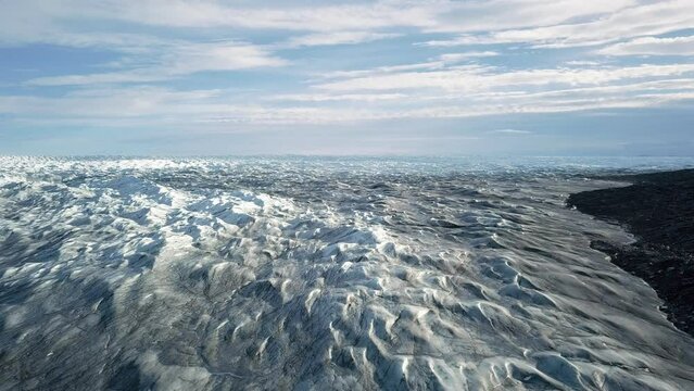 Aerial view over the icecap at pinot 660, just outside Kangerlussuaq, Greenland. Pull out, tilting down.