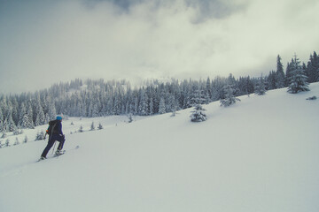 Skier climbing on mountain slope landscape photo. Beautiful nature scenery photography with fog on background. Idyllic scene. High quality picture for wallpaper, travel blog, magazine, article