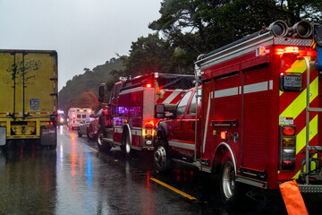Firetruck and ambulance at the scene of an accident on a rainy day. 