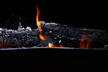 Burning red hot sparks fly from fire. Barbecue gril with glowing and flaming hot charcoal and...