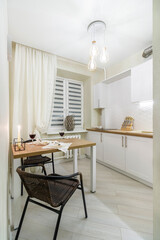 Rent of modern housing sale of new apartment, modern renovation. White furniture with utensils, shelves with crockery and plants in pots, refrigerator in simple minimal dining room, empty space.