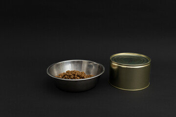 Dry dog food in an aluminum plate on a black background, dog food
