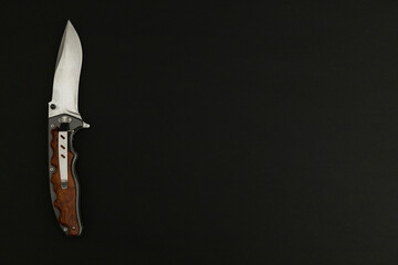 Tourist folding knife on black background