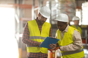 A shot of a man and woman working in a distribution warehouse, the manager is giving instructions to one worker.