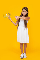 displeased teen girl in crown on yellow background