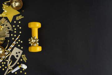 Yellow dumbbell and golden decorations, confetti, horn blower for New Year's Eve celebration....