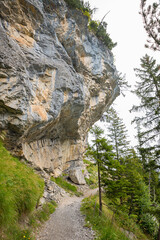 Fototapeta premium hiking trail around lake Oeschinensee, under overhanging rocks