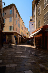 Fototapeta na wymiar view on the pedestrian of the old city of Hyères with shops on a sunny summerday with warm colours