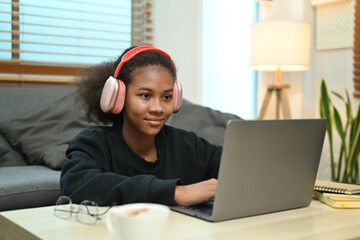 Concentrated teenage woman watching learning online in virtual classroom on laptop computer