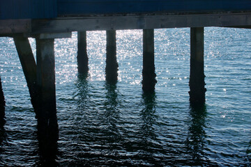 sunset reflection on the water under the pier