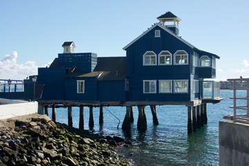 vintage waterfront building built on pylons in the harbor