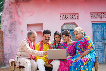 Indian farmers family using laptop at home.