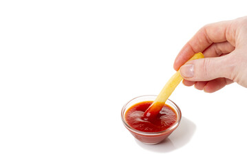 Hand dip french fries chips into ketchup isolated on white background with shaddow