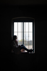 Fototapeta na wymiar Woman sitting at the window - silhouette 