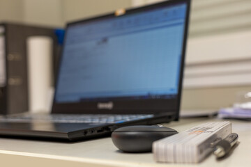 Arbeitsplatz eines Polier beim Bau mit Laptop, Maßstab, Kugelschreiber und Maus. Meist im Bokeh