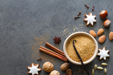 Christmas cookies, nuts and aromatic spices on dark background