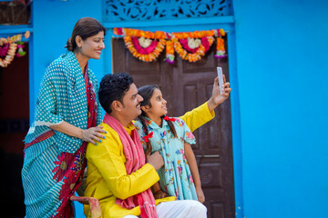 Obraz premium Indian farmer taking selfie with family at home
