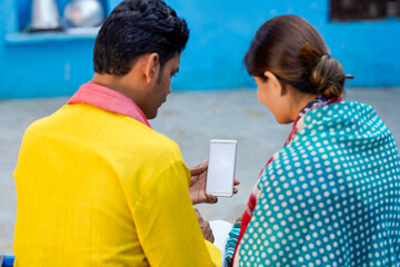 Obraz premium Indian farmer using smartphone with her wife