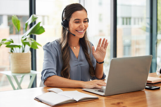 Video call, business woman and wave on laptop with headphones for communication, virtual meeting and global consulting in startup company. Happy female worker, smile and hello on computer conference