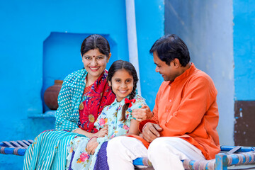 Happy indian farmer couple with his little girl.