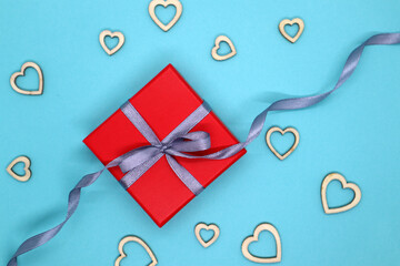 Red and gray theme gift box. Present gift with a bright red box. Blue background. Top view.