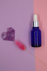 Container, cosmetic blue bottle, heart and dried flowers on a pink background. Blank label for branding mockup. Gift set for sale promotion.