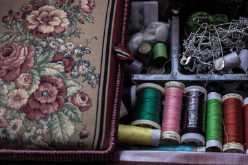Fototapeta na wymiar colored threads and various accessories for sewing inside a sewing box