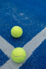 selective focus, two balls on a blue paddle tennis court where the lines meet