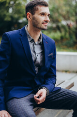 Obraz premium a man in a suit is sitting on a bench and smiling
