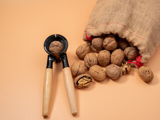 Walnut and nutcracker on orange background. Raw walnut.