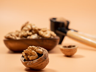 Walnut and nutcracker on orange background. Raw walnut.