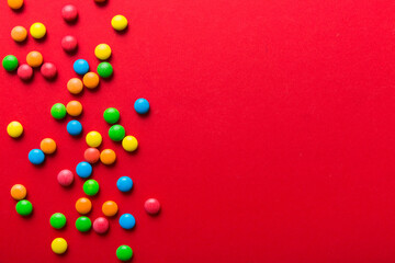 Mixed collection of colorful candy, on colored background. Flat lay, top view. frame of colorful chocolate coated candy