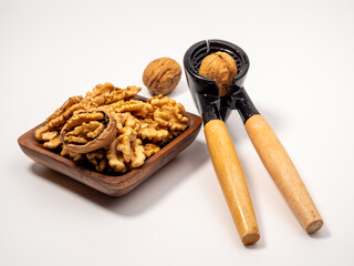 Walnut and nutcracker on a white background. Raw walnut.