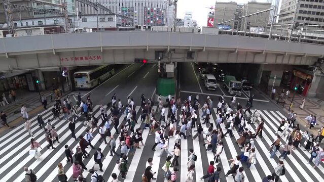 OSAKA, JAPAN : Aerial high angle view of crowd of people walking at zebra crossing and train near Osaka station. Commuters at busy rush hour. Japanese lifestyle and business concept. Time lapse shot.